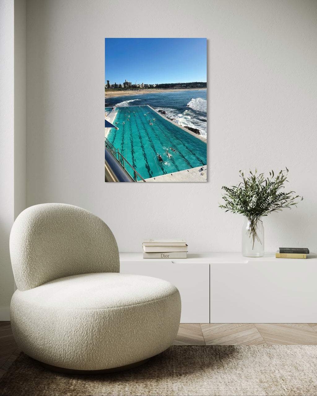 Modern chair in a room with a large wall art of a pool scene.
