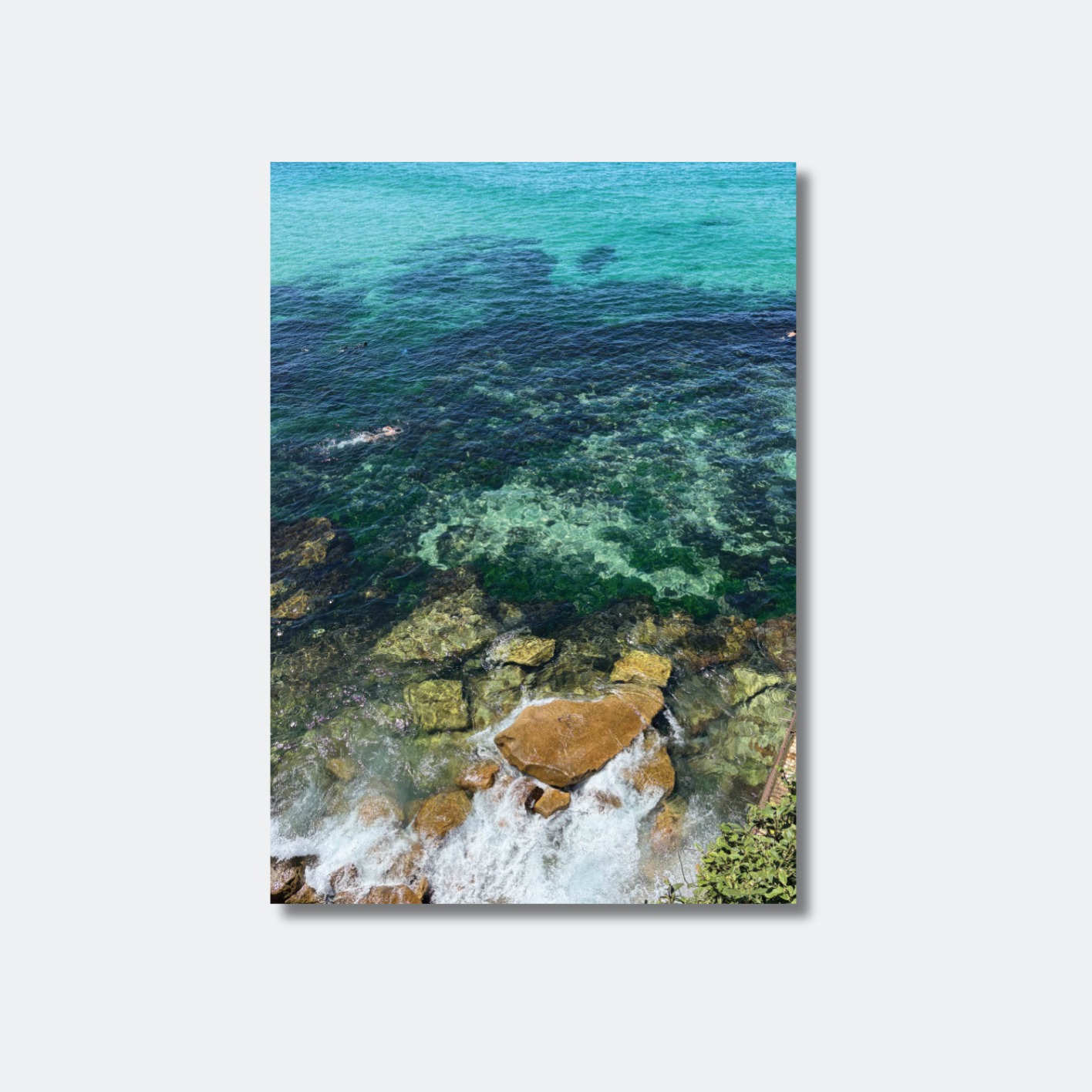 Canvas print of a coastal scene with clear blue water and rocks.